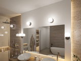 Modern bathroom with round glass and chrome wall lights, bright LED lighting, and natural stone wall.