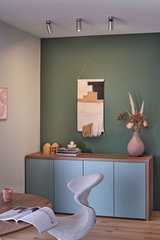 Moderne woonkamer met blauwe houten kast, groene wanddecoratie en zilveren plafondspots voor sfeerverlichting