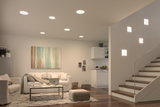 Modern living room with white recessed ceiling lights and square wall lamps on staircase