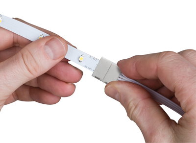 Mains connectant une bande LED blanche avec connecteur pour éclairage LED et technologie lumineuse.