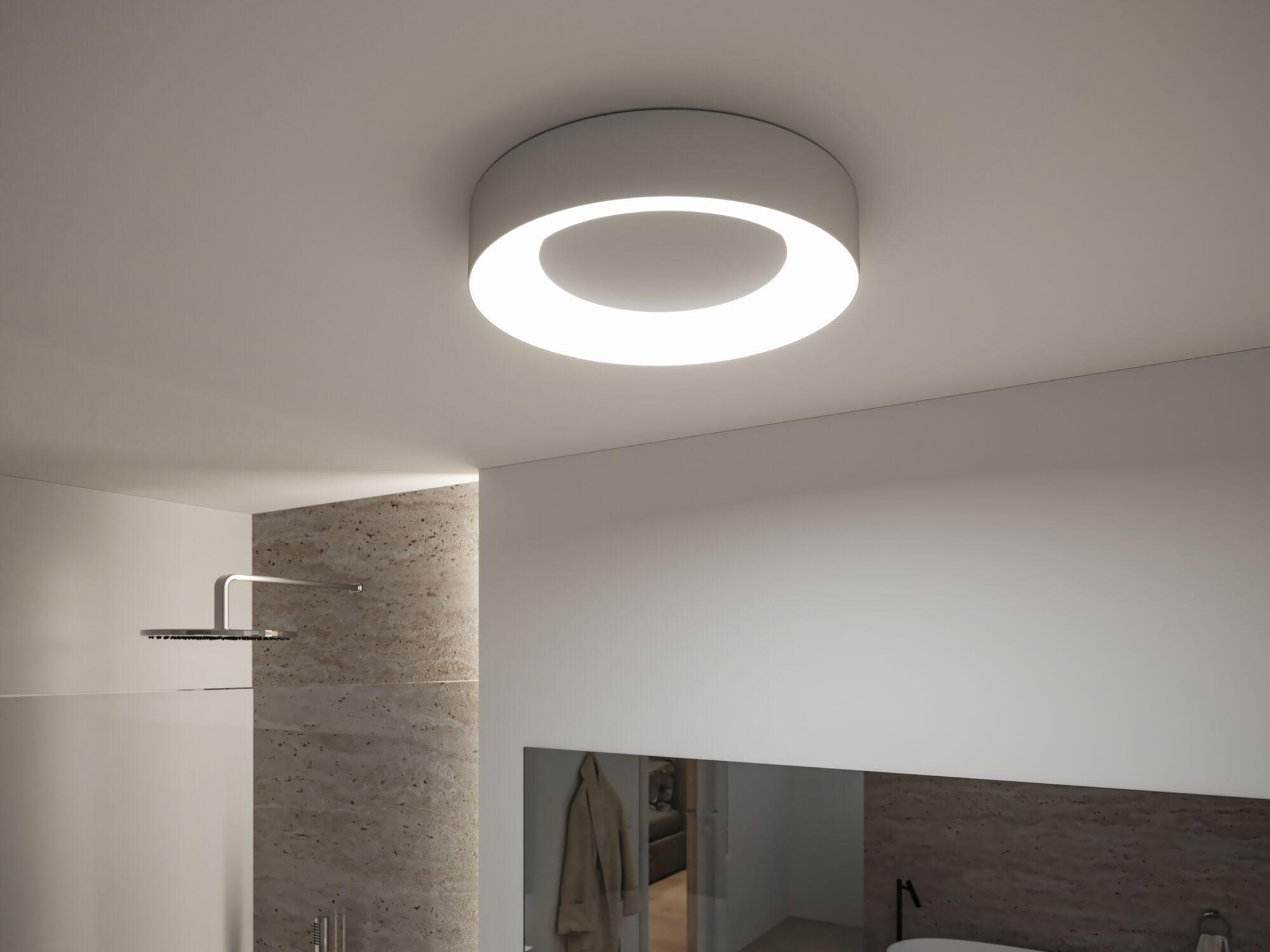 Runde weiße LED-Deckenleuchte mit modernem Design in Badezimmer mit Natursteinwand