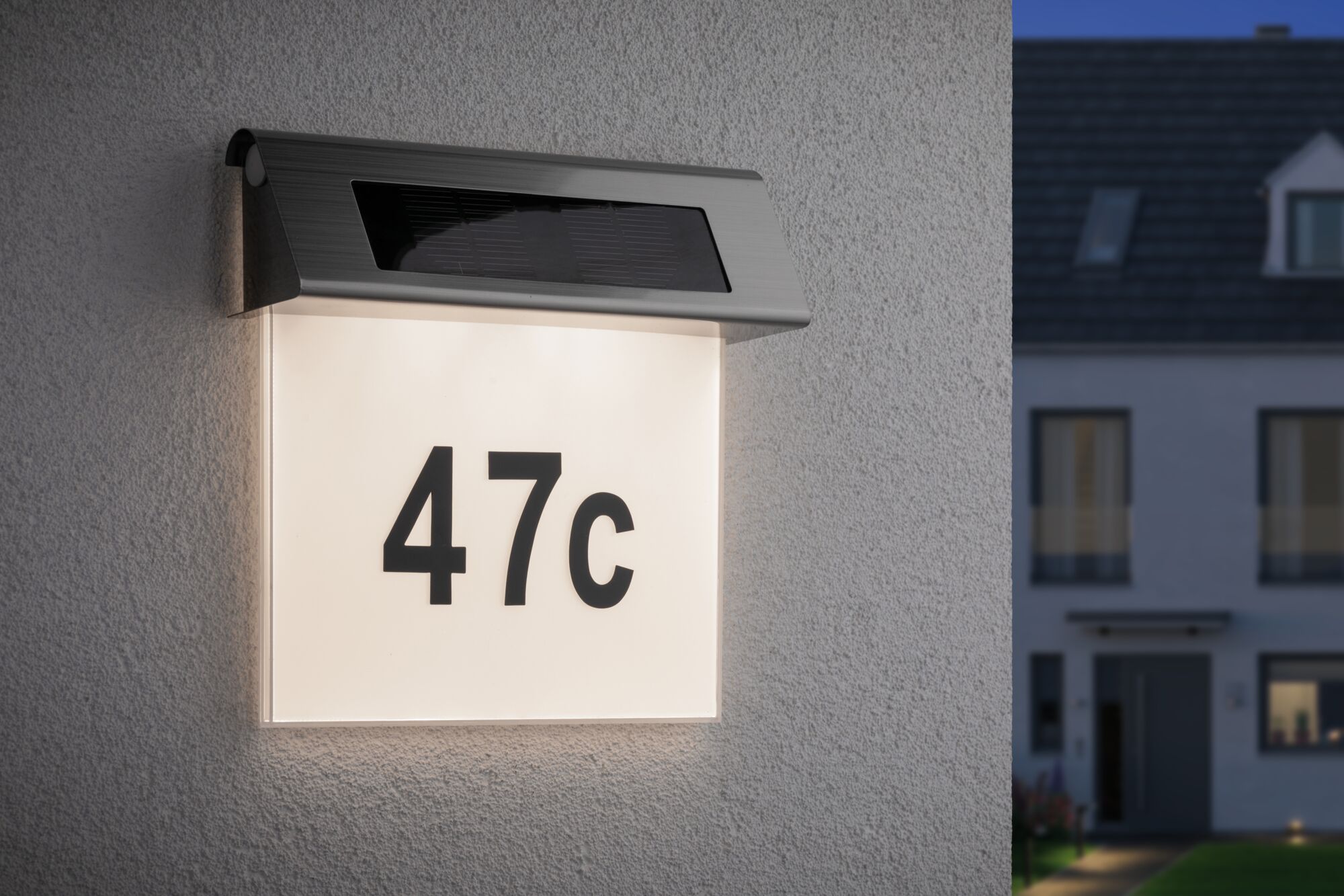 Verlichte huisnummer 47c met zonne-energie roestvrijstalen lamp aan witte muur