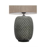 Table lamp with grey textured ceramic base and beige fabric shade for ambient home lighting