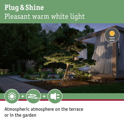 Garden with warm white LED outdoor lighting and modern wooden terrace creating atmospheric ambiance