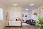 Salon moderne avec plafonniers ronds diffusant une lumière blanche chaude et décoration minimaliste