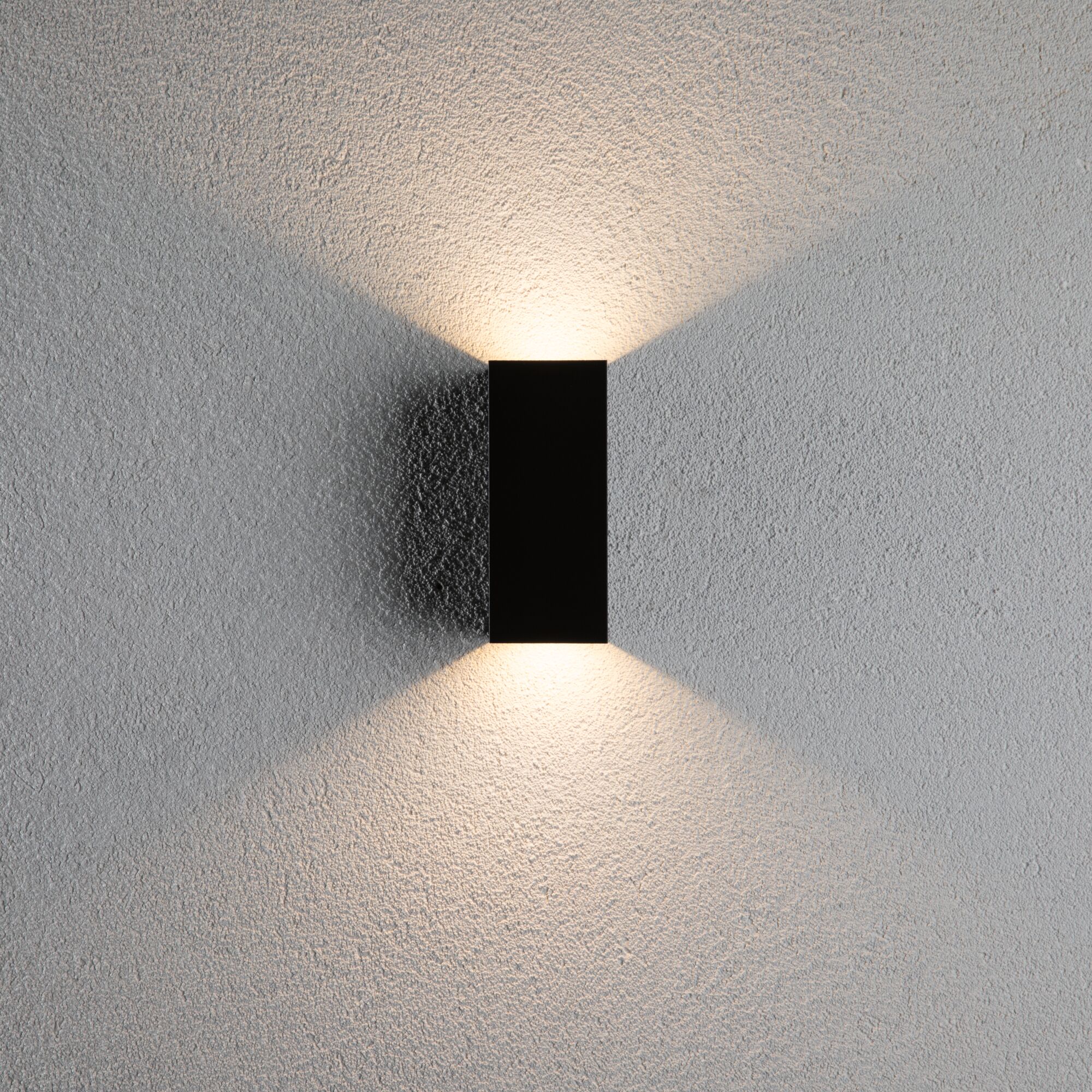 Schwarze rechteckige Wandleuchte aus Metall mit warmweißem Licht nach oben und unten