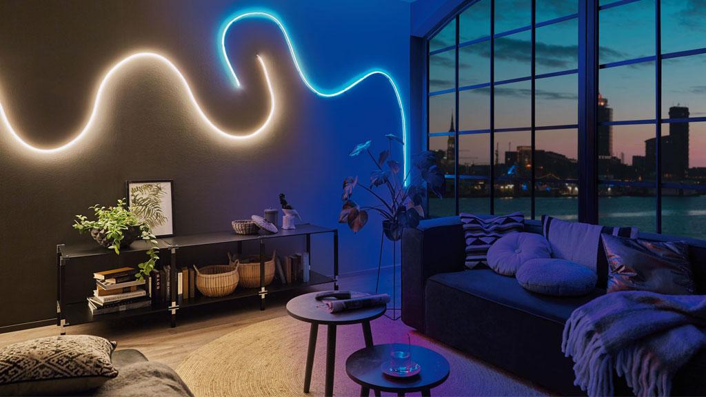 Modernes Wohnzimmer mit LED-Lichtschlauch in Weiß und Blau an Wand, urbaner Ausblick bei Abenddämmerung