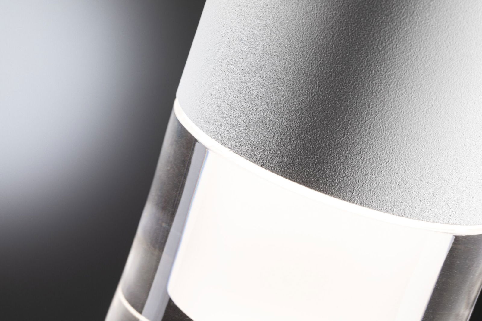 Close-up van moderne grijze LED-buitenlamp met helder glas en wit licht voor tuinverlichting