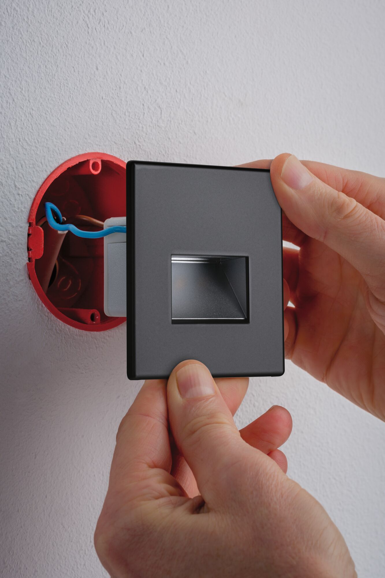 Installation d'un spot mural encastré LED carré noir mat avec pilote intégré et connexion câblée.