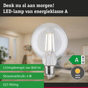 Transparante LED-lamp met warm wit licht en ultra-efficiënt energieverbruik tegen groene bosachtergrond
