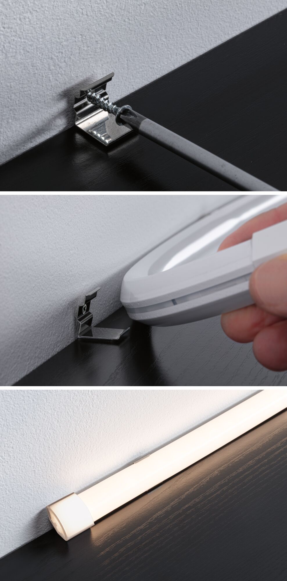 Installation of silver metal bracket on white wall and black surface for LED light fitting