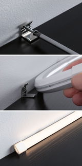 Installation of silver metal bracket on white wall and black surface for LED light fitting