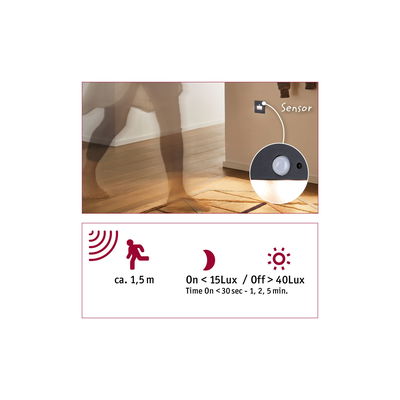 Black motion sensor mounted on wall above rug for automatic light control in hallway or room