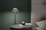 Lampe de table moderne grise en métal avec abat-jour en tissu sur table de chevet près d'un lit rembourré gris