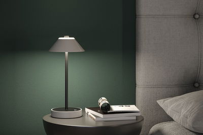 Lampe de table moderne grise en métal avec abat-jour en tissu sur table de chevet près d'un lit rembourré gris