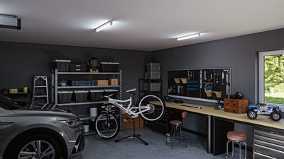 Moderne garage med grå bil, cykel på reparationsstander, organiseret arbejdsbord og klare LED-loftslamper