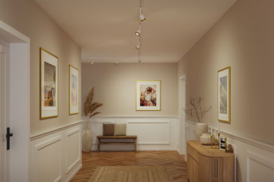 Hallway with white walls, wooden bench, rug and modern warm beige LED track lighting for home decor.