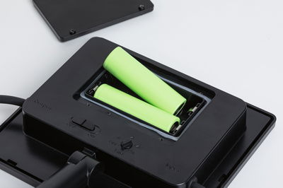 Chargeur noir avec deux piles rechargeables AA vertes et interrupteur marche/arrêt intégré