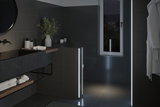 Modern bathroom with dark tiles and LED light strips providing ambient lighting effect