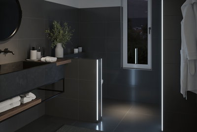 Modern bathroom with dark tiles and LED light strips providing ambient lighting effect