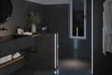 Modern bathroom with dark tiles and LED light strips providing ambient lighting effect