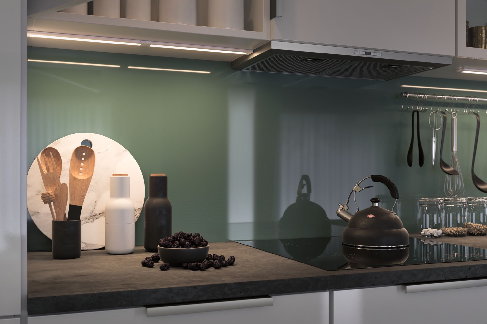 Cuisine moderne avec crédence en verre vert, bouilloire noire et ustensiles en bois sur plan de travail foncé