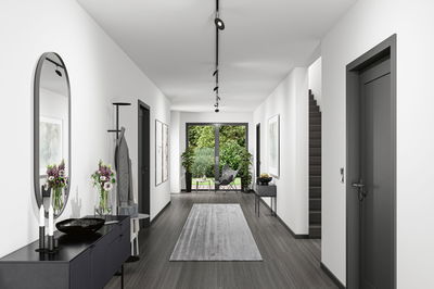 Moderner Flur mit grauem Boden, schwarzen Türen, Spiegel und minimalistischer Deckenbeleuchtung für Wohnräume