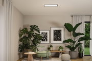 Salon moderne avec fauteuil vert, table d'appoint en bois, grandes plantes d'intérieur et luminaire de plafond minimaliste