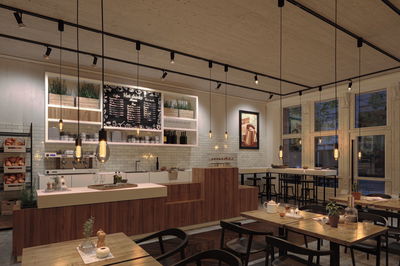 Modern café interior with wooden counter, white tiles, and warm LED pendant lights for cozy lighting.