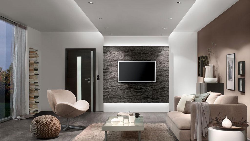 Modernes Wohnzimmer mit LED-Einbaustrahlern in weißer Decke und gemütlicher Sitzgruppe in Beige und Braun.