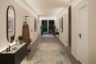 Modern hallway with warm white indirect LED wall lighting, wooden floor and stylish interior design.