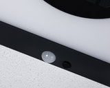 Gros plan sur cadre de lampe LED noir avec détecteur de mouvement blanc sur mur blanc