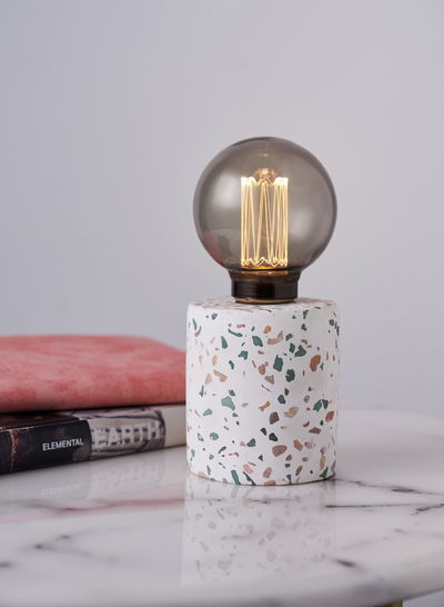 Lampe de table moderne avec base en marbre terrazzo et ampoule LED en verre fumé ronde sur surface en marbre