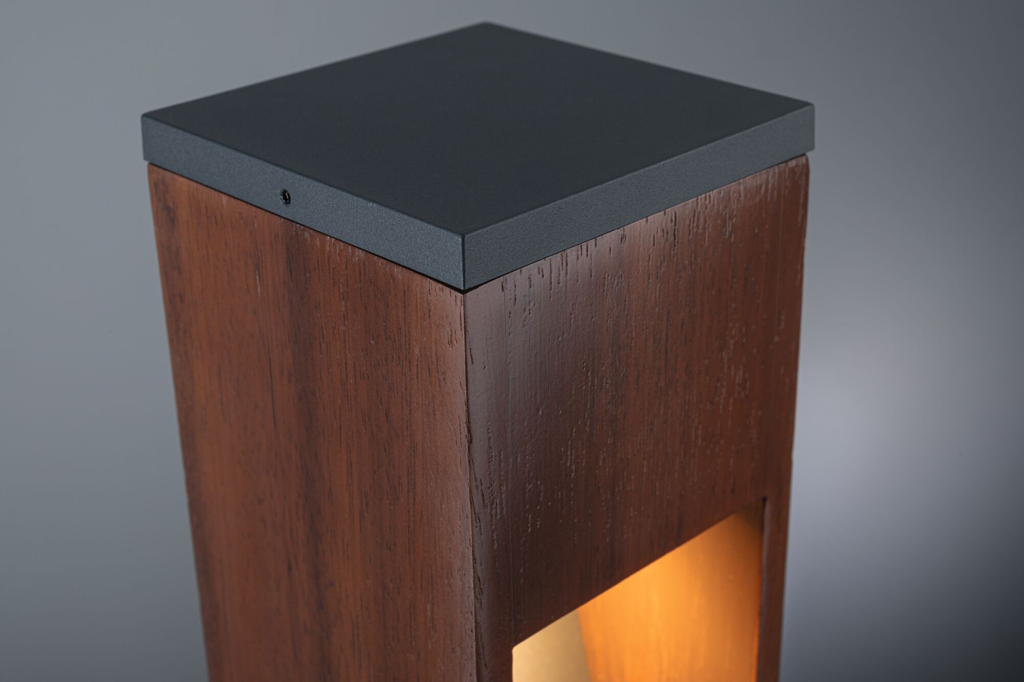 Modern outdoor wooden post light with black metal top and warm lighting accent for garden.