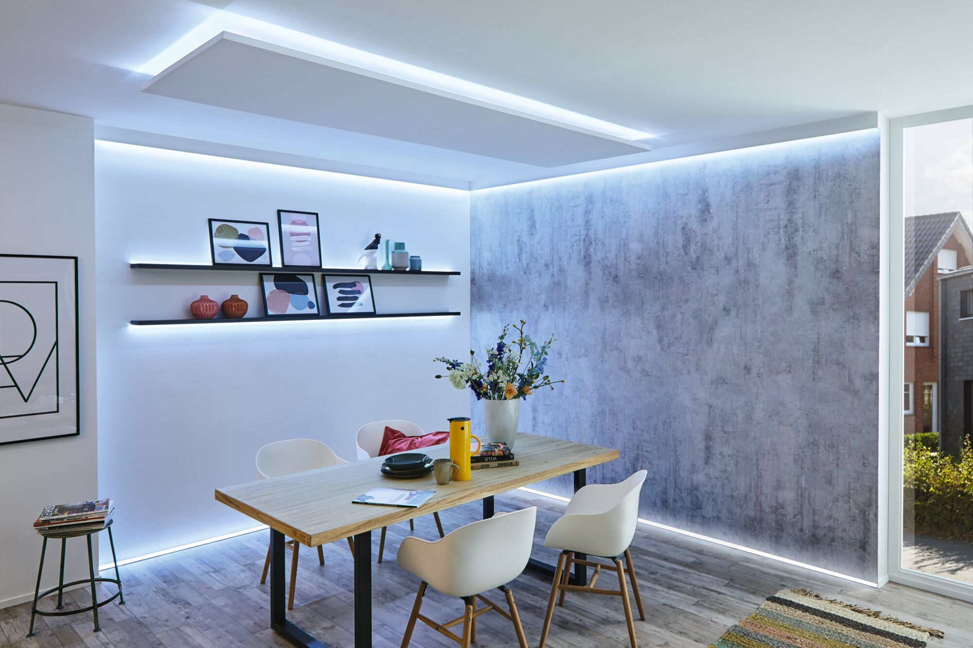 Modernes Esszimmer mit Holz-Tisch, weißen Stühlen und LED-Indirektbeleuchtung an Wänden und Decke