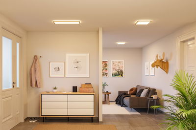 Modernes Wohnzimmer mit quadratischen Deckenleuchten in warmweißem Licht und minimalistischer Einrichtung