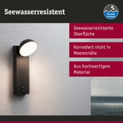 Schwarze Außenwandleuchte mit seewasserresistenter Oberfläche und warmweißem Licht an grauer Wand