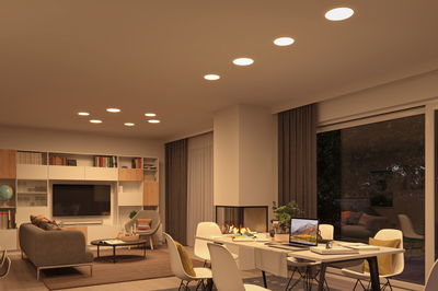 Modern living room with warm white LED recessed lights in ceiling and cozy furniture setup.