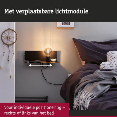 Zwart wandplankje met verplaatsbare lichtmodule en lamp naast bed met donkere beddengoed