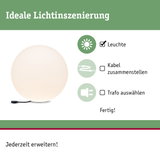 Weiße Kugelleuchte mit schwarzem Kabel auf grünem Hintergrund für Lichtinszenierung und Beleuchtung