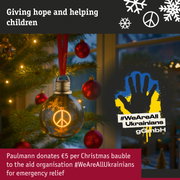 Brown LED Christmas bauble with peace symbol on tree supporting emergency aid for Ukrainians