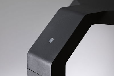 Nahaufnahme eines mattschwarzen Metallrahmens mit kleinem Sensor für moderne LED-Beleuchtung.