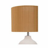 Table lamp with white ceramic base and brown fabric shade for cozy lighting