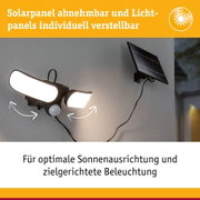 Schwarze Solarleuchte mit drei verstellbaren LED-Panels und abnehmbarem Solarpanel an grauer Wand