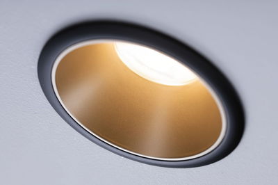 Round recessed LED light with gold reflector and black frame for modern interior lighting solutions