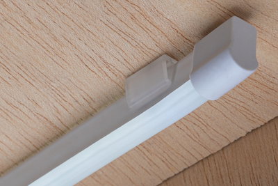 Lumière LED blanche sous meuble avec boîtier en plastique sur surface en bois pour éclairage économique