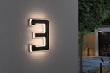 Modern black house number 3 with LED lighting on grey exterior wall for garden and entrance