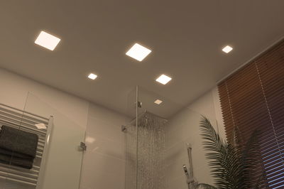 Modernes Badezimmer mit quadratischen LED-Deckenleuchten in warmweiß und Glasdusche mit Regenduschkopf