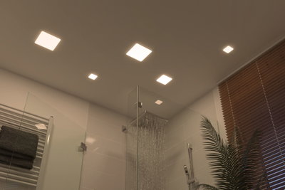 Modernes Badezimmer mit quadratischen LED-Deckenleuchten in warmweiß und Glasdusche mit Regenduschkopf