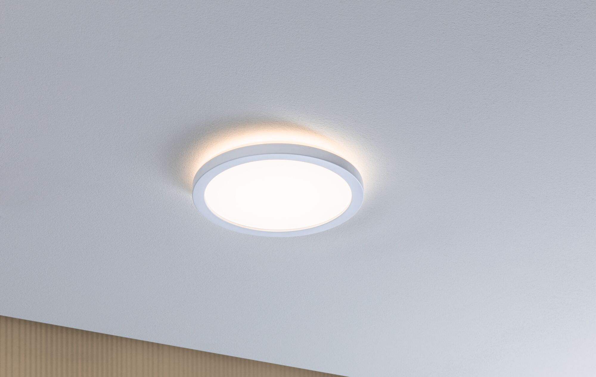 Round white LED ceiling light made of plastic with warm white light for modern interiors